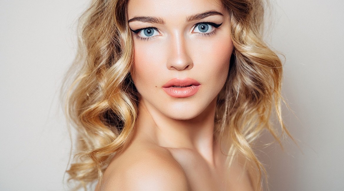 Junge Frau sinnlich schauend mit lockigen blonden Haaren